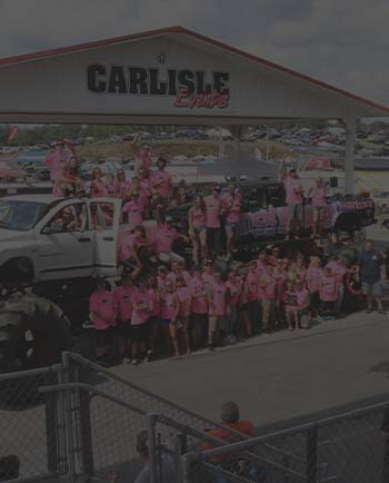 A club posing for a photo with their trucks